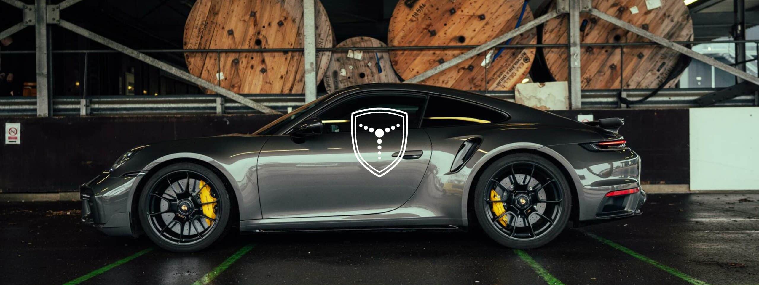 Porsche 911 in een loods, met het schildlogo van Amsterdam Car Company