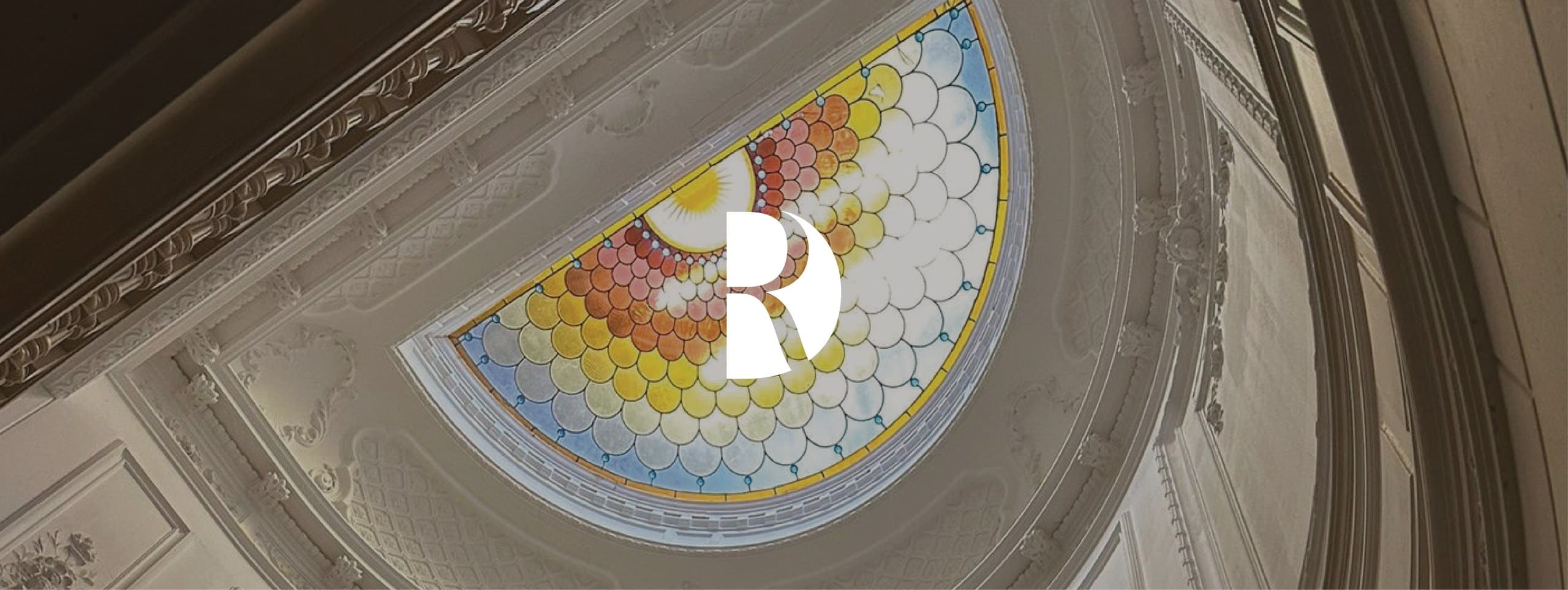 Het monogram van DAM Residence over het glas-in-loodplafond van het pand